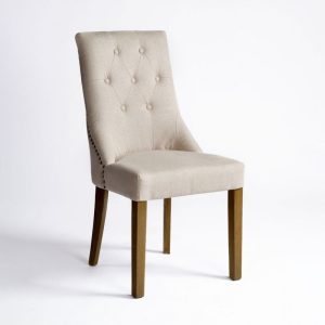 Silla tapizada en lino con patas de roble y detalles capitoné